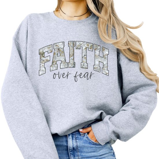 Close-up of Faith Over Fear collegiate lettering print detail on army green sweatshirt