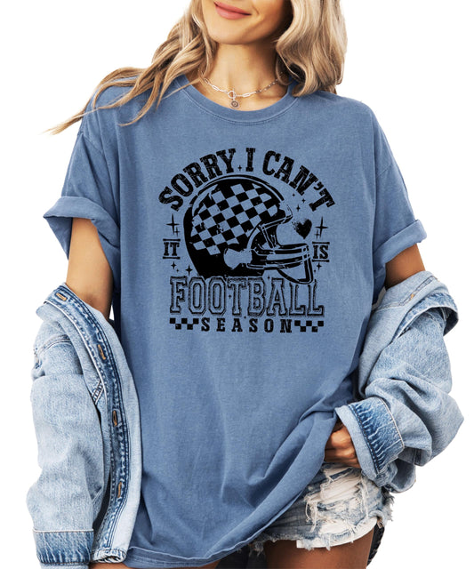 Women's blue football graphic tee with Sorry I Can't It's Football Season text and checker helmet design