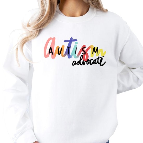 Close-up of vibrant Autism Advocate graphic print on a white women's sweatshirt