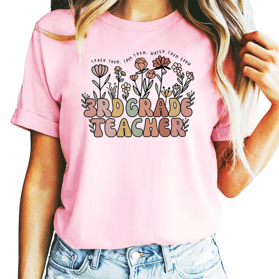 Women's 3rd grade teacher t-shirt with floral hand-drawn design and text Teach Them Love Them Watch Them Grow in peach