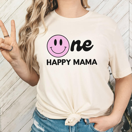 Dad holding baby in coordinating One Happy Family first birthday matching shirts