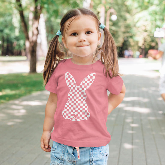Flat lay of peach girls bunny Easter graphic tee by Olive Loves Apple
