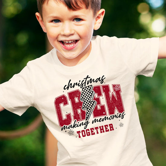 Christmas Crew 2024 matching family holiday tee with bold checkered lightning graphic design on natural fabric