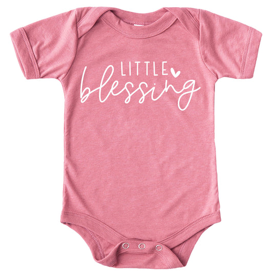 Peach newborn baby girl bodysuit with white Little Blessing heart graphic, laid flat