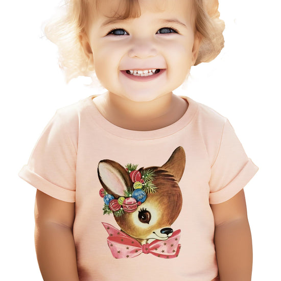 Close-up of reindeer wreath graphic print on peach kids Christmas t-shirt showing print quality detail