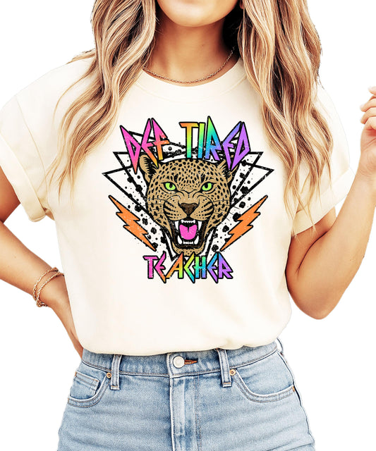Def Tired Teacher ivory graphic tee with retro tiger face and neon lightning bolt text design