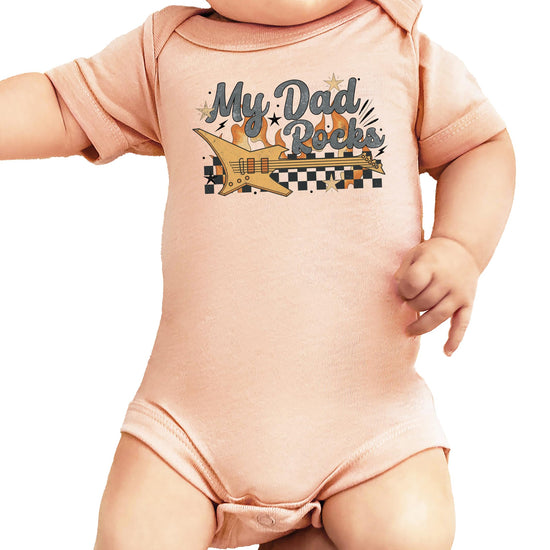 Close-up of rockstar dad retro guitar print on peach infant snap-bottom bodysuit