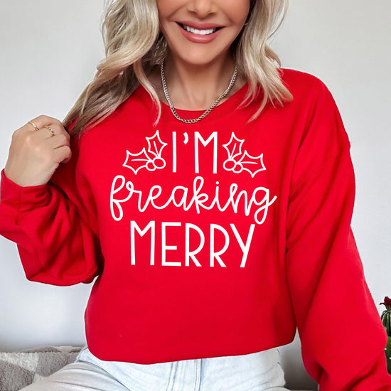Close-up of 'I'm Freaking Merry' graphic print on a red Christmas sweatshirt