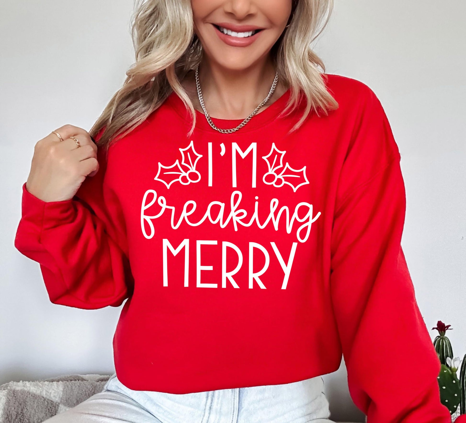 Close-up of 'I'm Freaking Merry' graphic print on a red Christmas sweatshirt