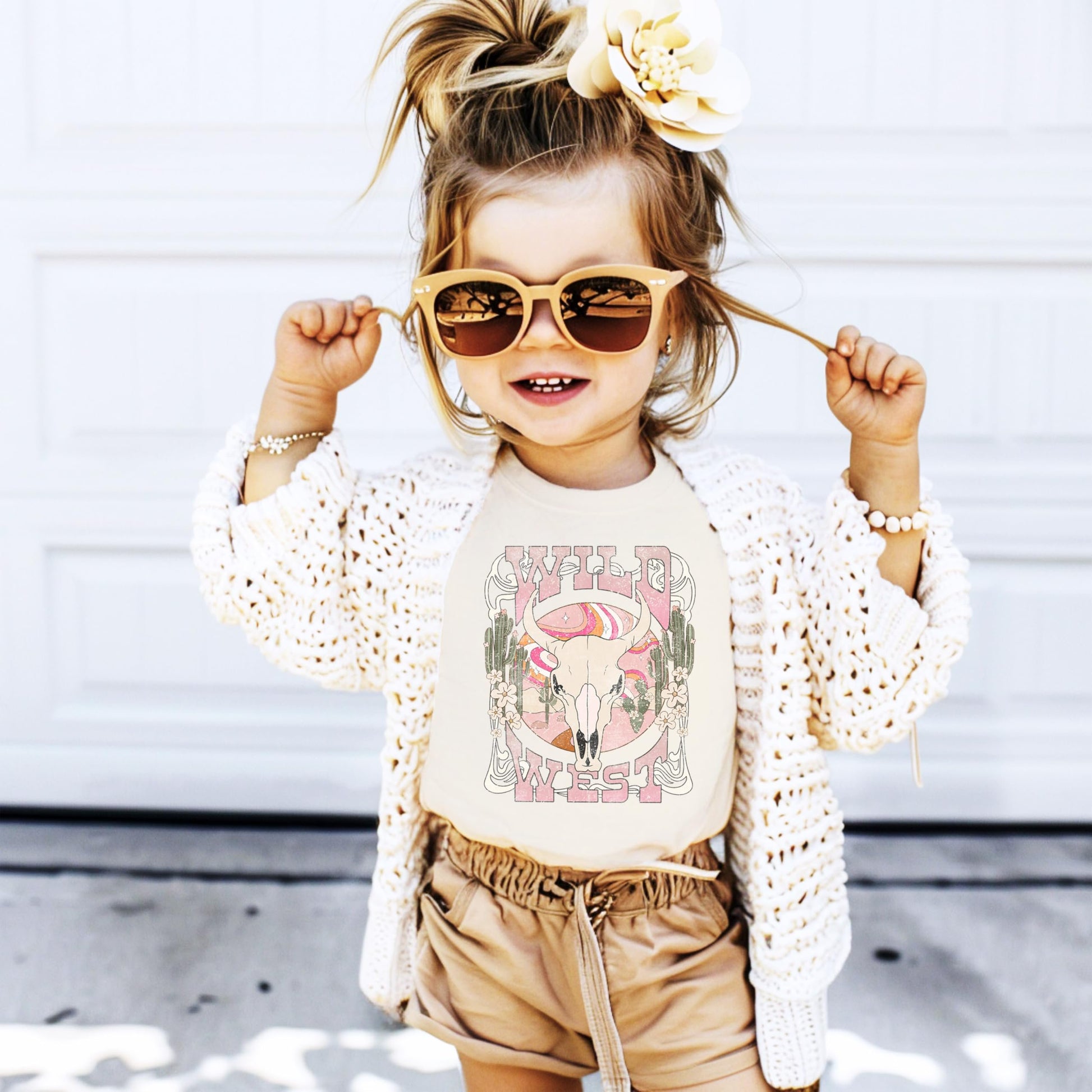 Close-up of steer skull with cactus and desert elements graphic print on natural youth tee by Olive Loves Apple