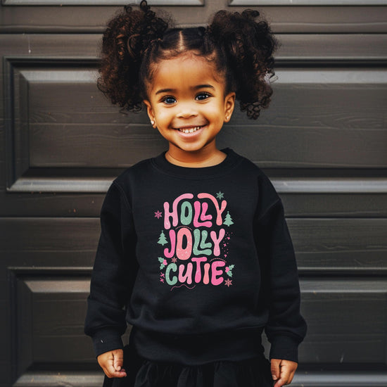 Side or back view of black kids holiday sweatshirt with Holly Jolly Cutie graphic print