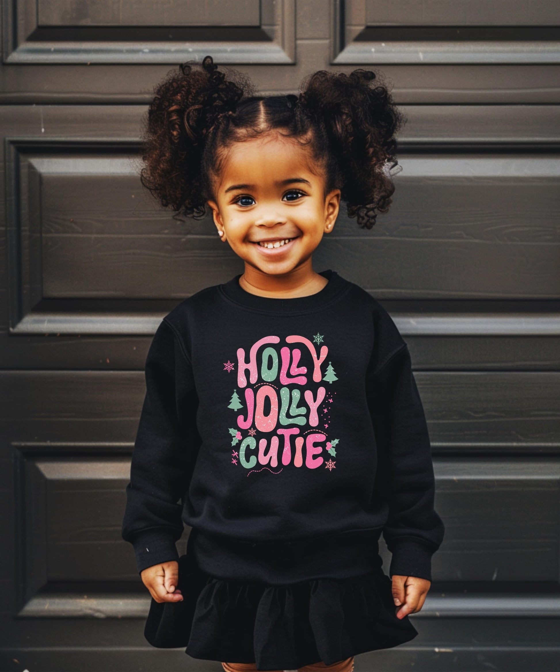 Side or back view of black kids holiday sweatshirt with Holly Jolly Cutie graphic print