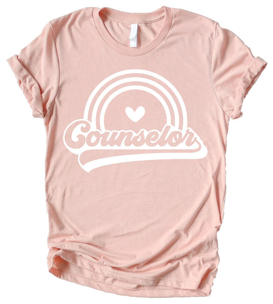 Women's retro rainbow counselor graphic tee in peach, perfect for back to school