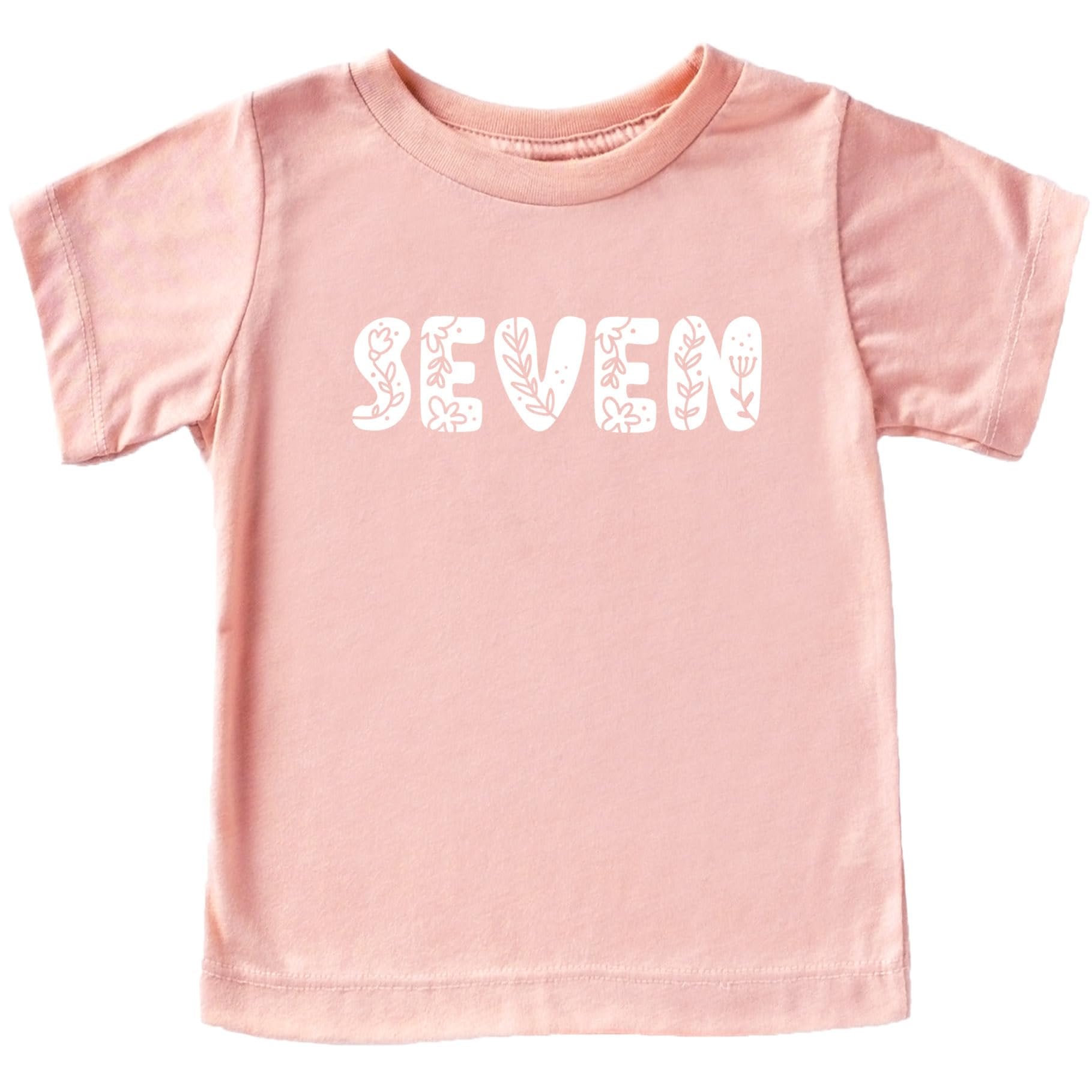 Toddler girl wearing mauve floral number birthday shirt, front view