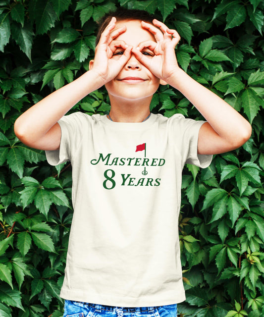 Close-up of Mastered 8 Years golf birthday graphic tee design on natural kids shirt