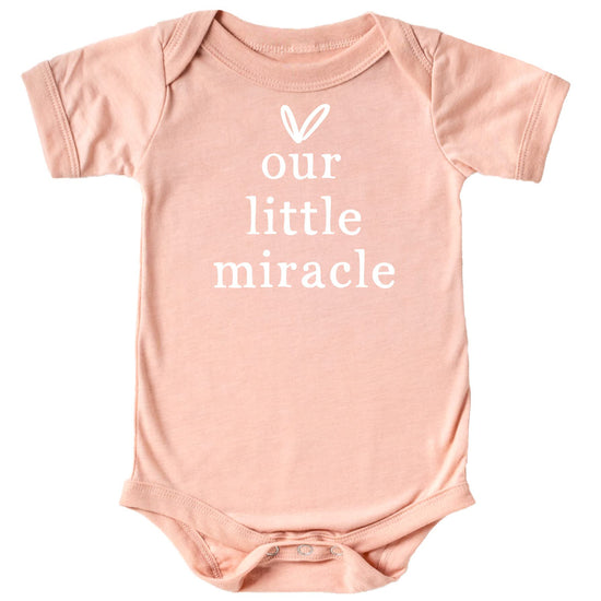 Military green infant snap bodysuit with white Our Little Miracle heart graphic, flat lay
