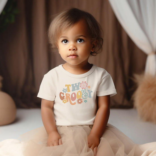 Flat lay of Two Groovy daisy 2nd birthday shirt with size and design details