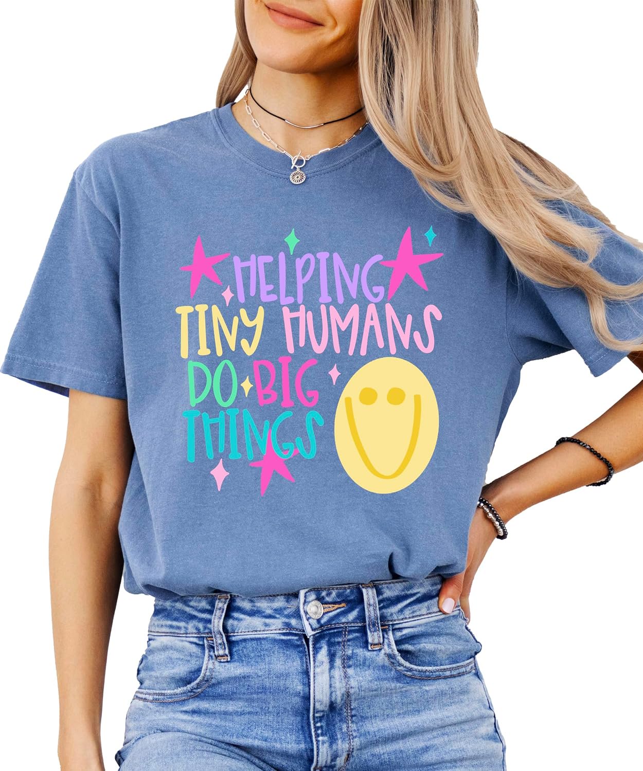 Close-up of Helping Tiny Humans Do Big Things pastel hand-lettered design with stars and retro doodle on a teacher graphic tee