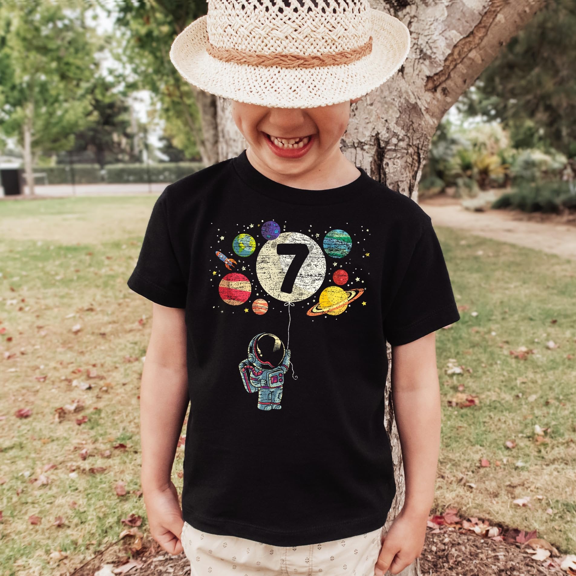 Child wearing vintage royal blue 7th birthday astronaut graphic tee with space design