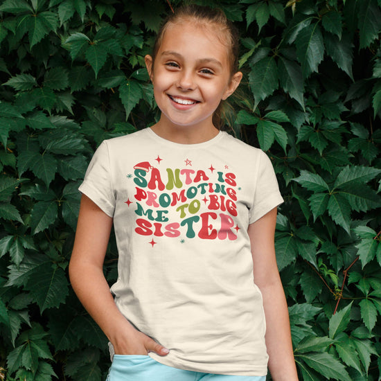 Youth model wearing natural Santa promoting big sister holiday t-shirt for size reference