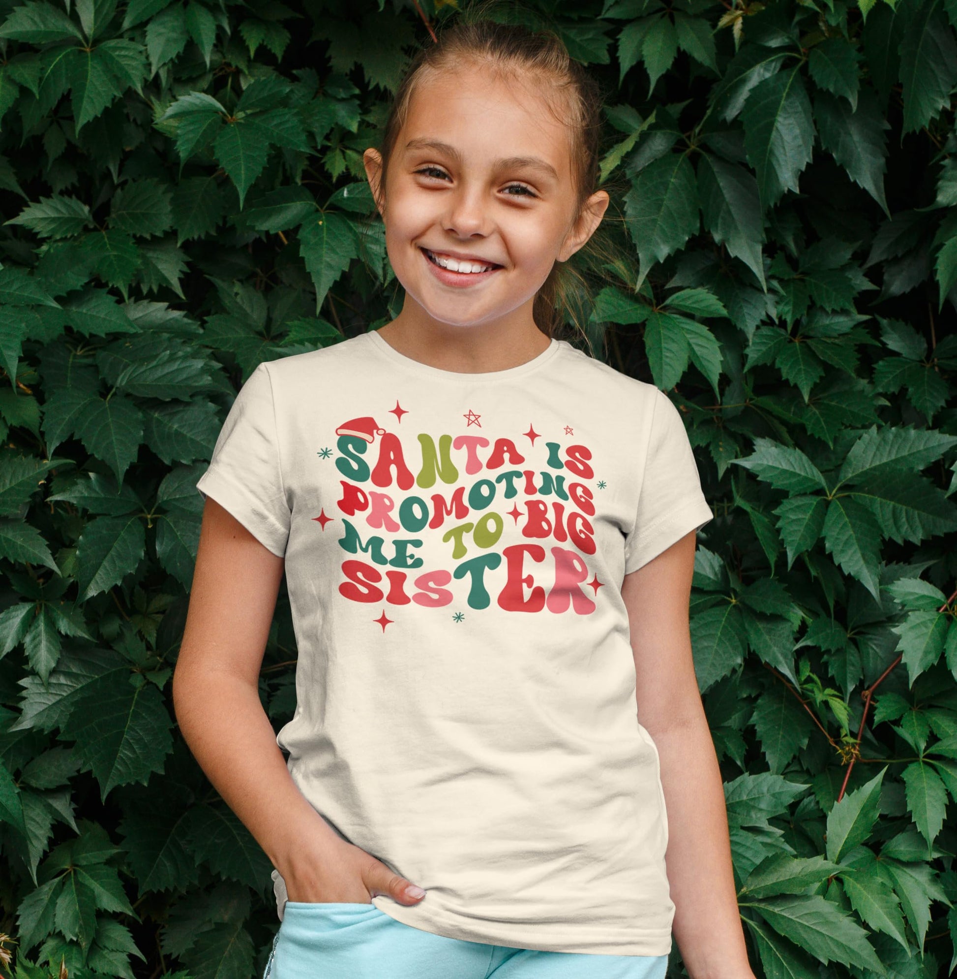 Youth model wearing natural Santa promoting big sister holiday t-shirt for size reference