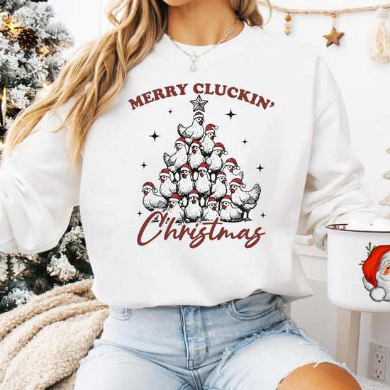 Flat lay of white Merry Cluckin' Christmas women's sweatshirt on neutral background