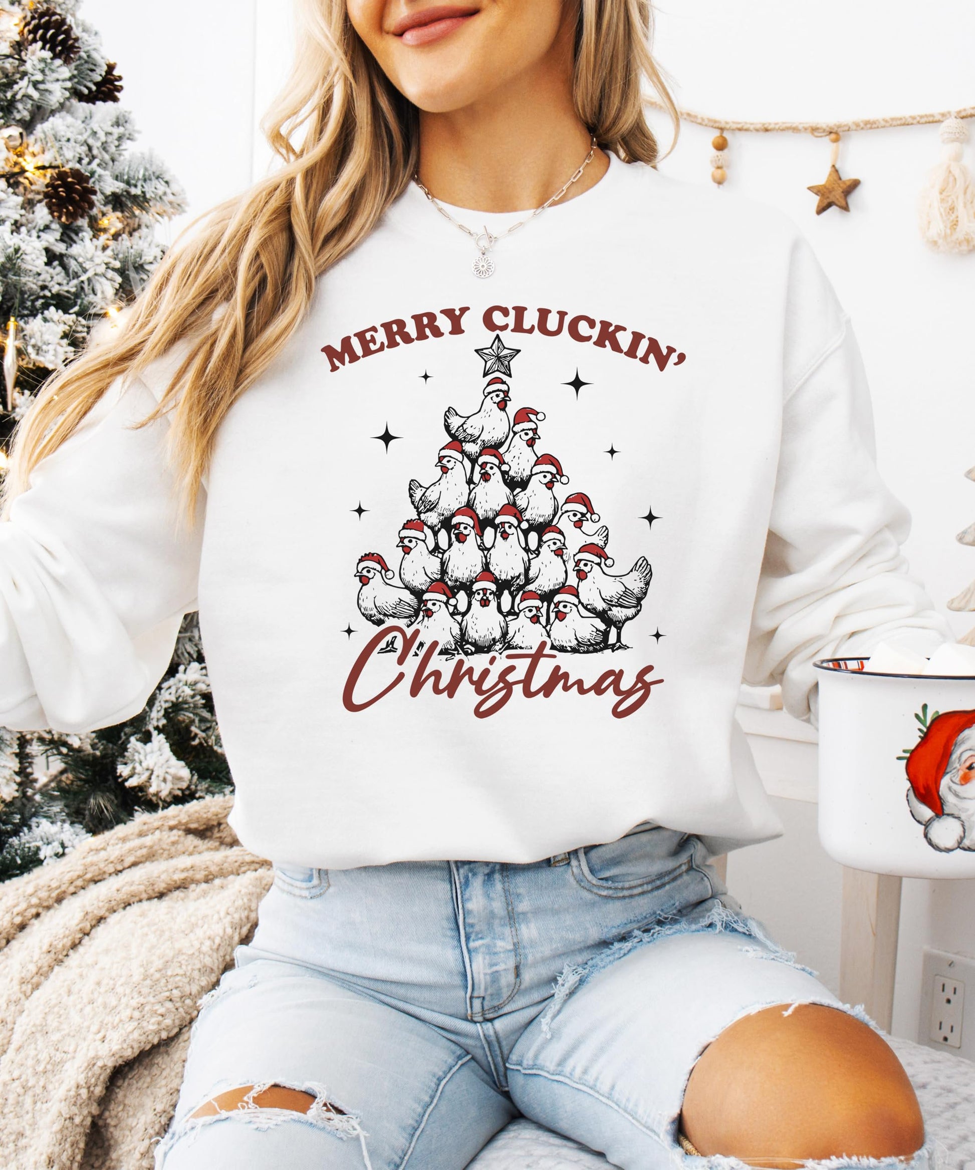 Flat lay of white Merry Cluckin' Christmas women's sweatshirt on neutral background
