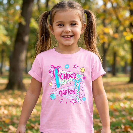 Back-to-school girls graphic tee in natural color with kindergarten pennant design, printed in the USA by Olive Loves Apple