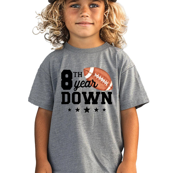 Close-up of '8th Year Down' football graphic print on youth birthday tee
