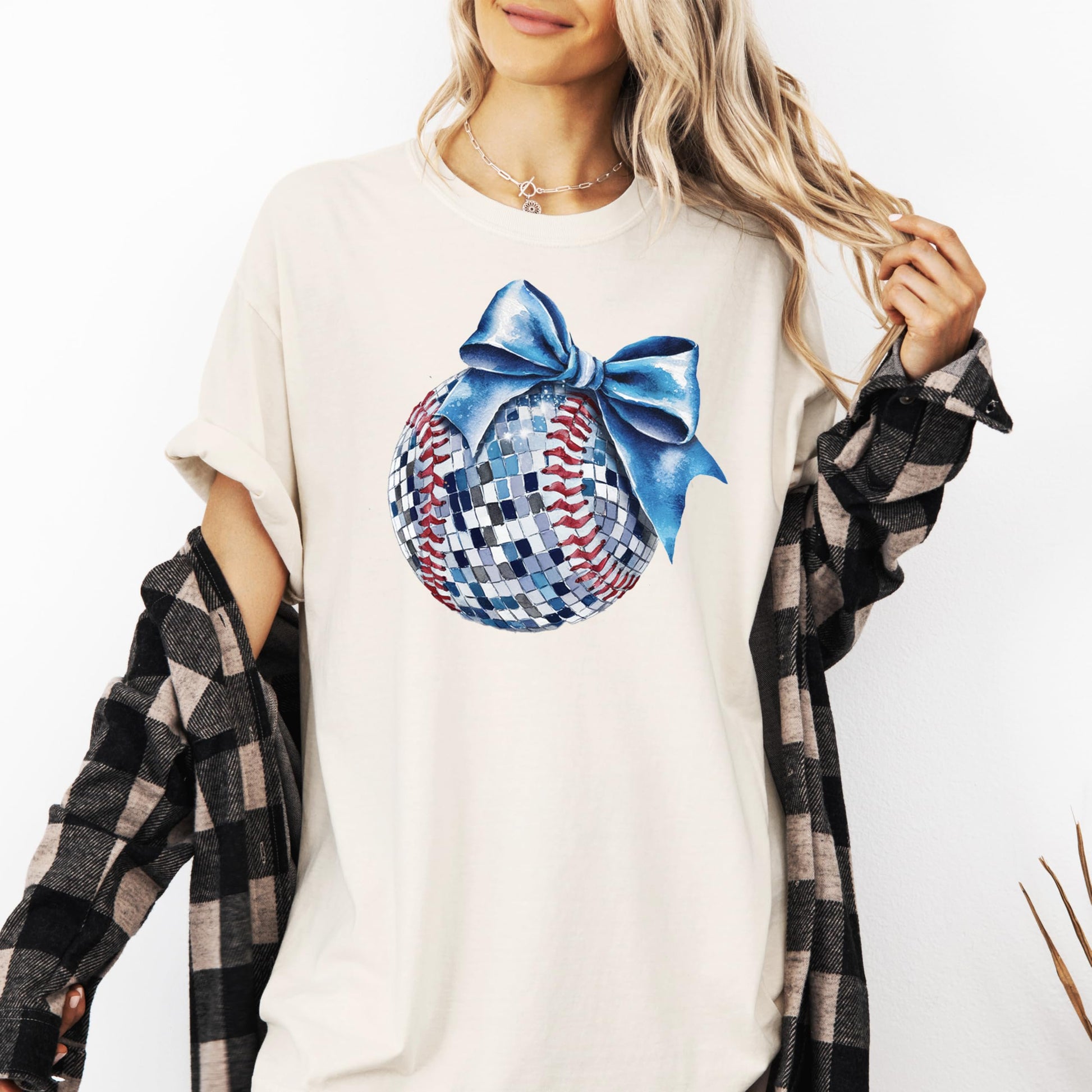 Flat lay of disco softball graphic tee with blue bow accent, showing full design and shirt color