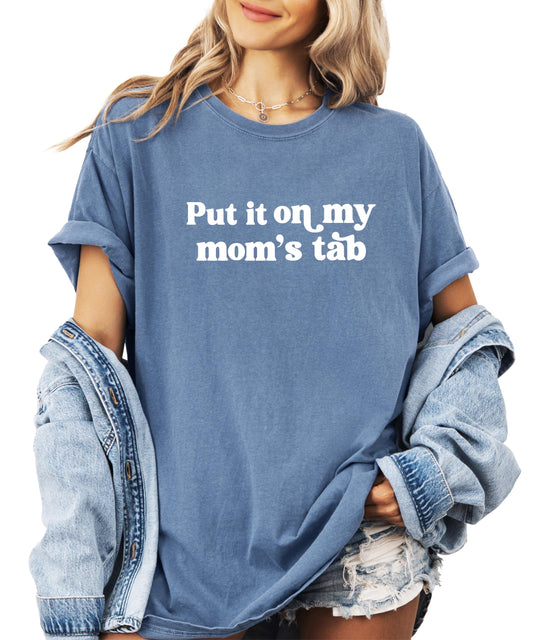 Woman wearing Put it on My Mom's Tab funny graphic t-shirt in casual setting