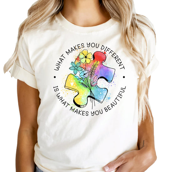 Close-up view of vibrant puzzle piece design with floral watercolor elements on pink shirt
