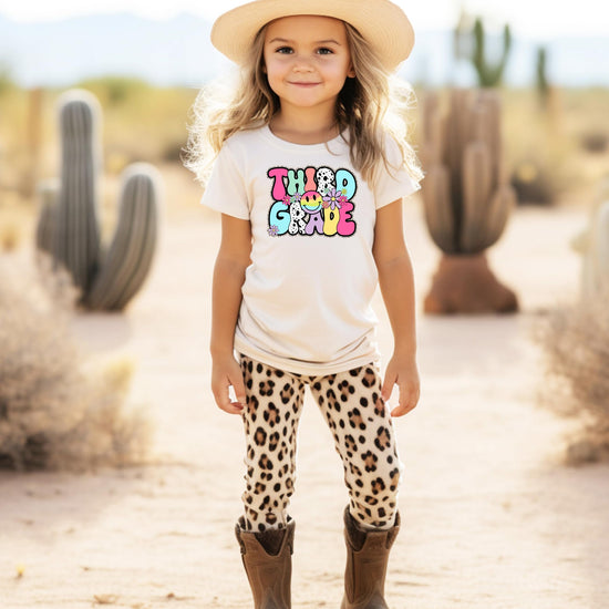 Flat lay of girls groovy 3rd grade graphic shirt in natural color with retro floral design
