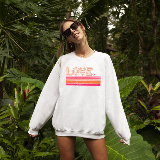 Side or lifestyle view of retro groovy Love sweatshirt for Valentine's Day