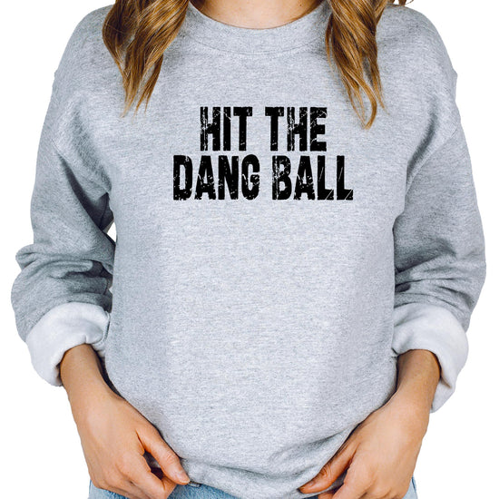 Close-up of distressed Hit The Dang Ball baseball print on red women's crewneck sweatshirt