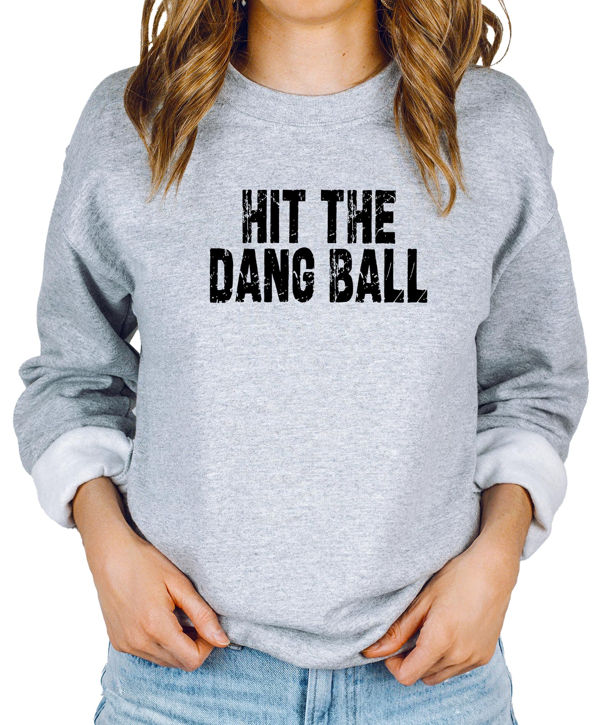 Close-up of distressed Hit The Dang Ball baseball print on red women's crewneck sweatshirt