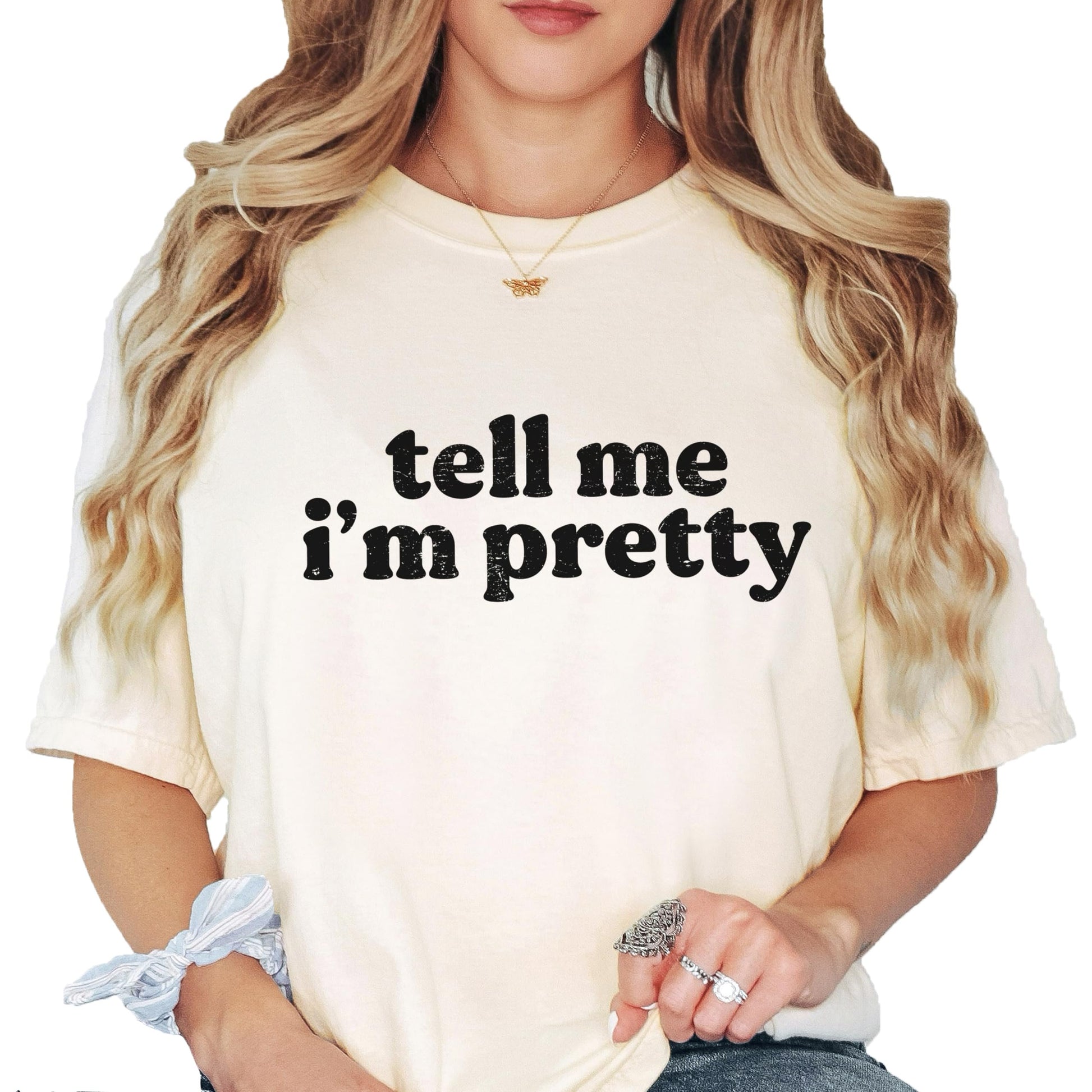 Model wearing Tell Me I'm Pretty ivory graphic tee styled casually