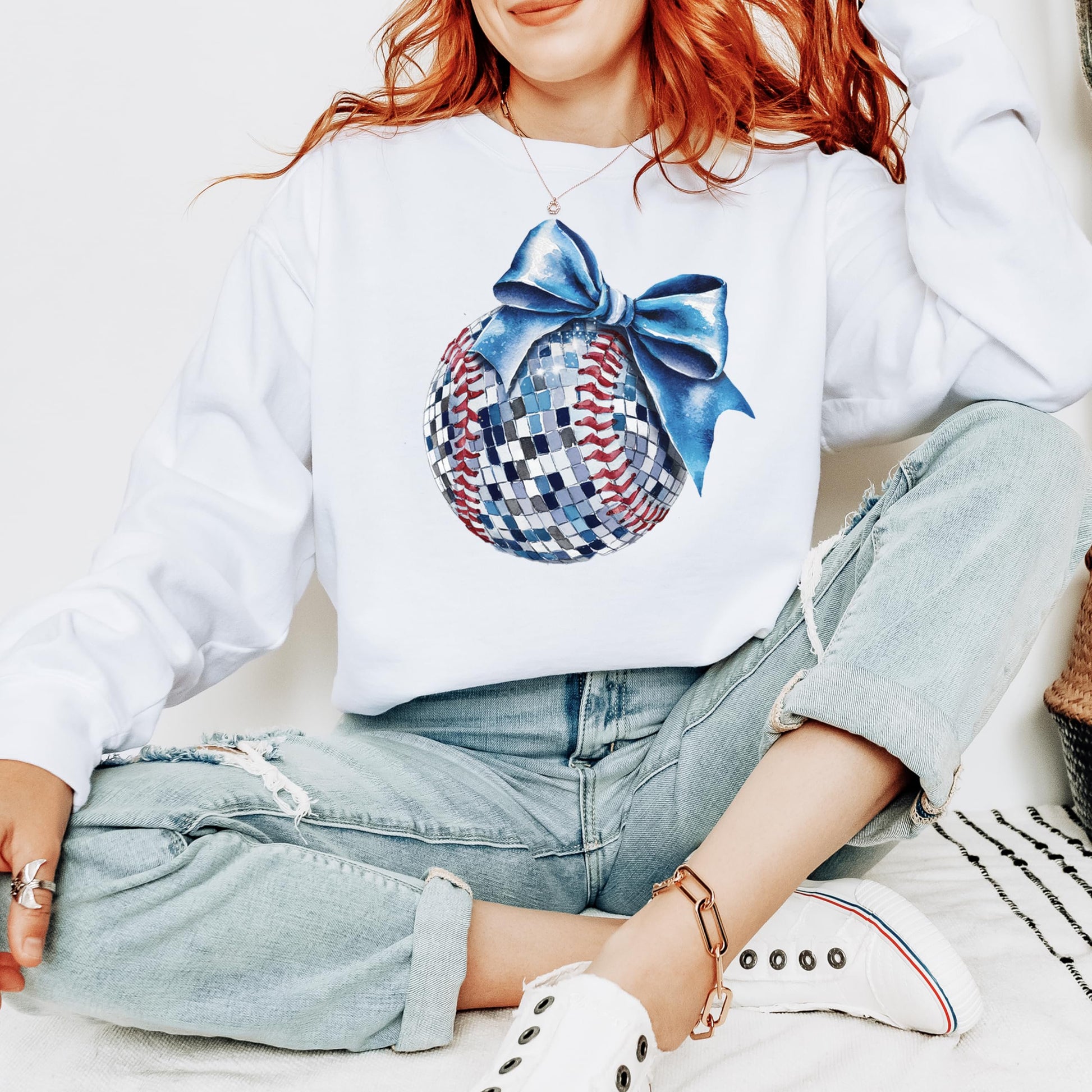 Detail shot of vibrant blue bow and disco ball softball print on gray sweatshirt