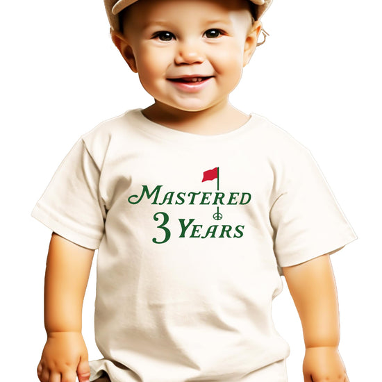 Close-up of Mastered 3 Years golf birthday graphic on a natural colored toddler shirt