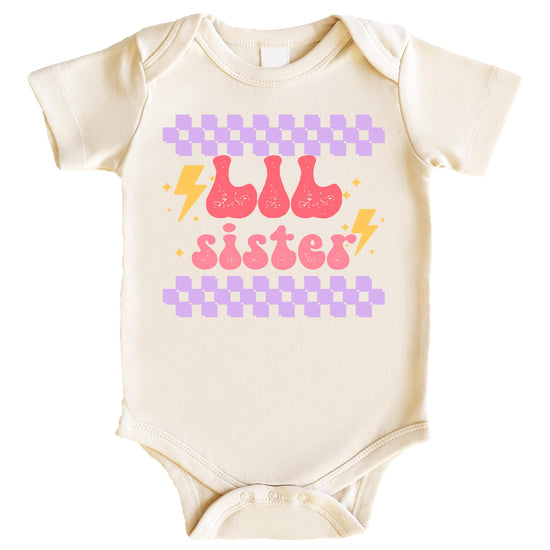 Close-up of retro lightning bolt little sister print on kids graphic tee
