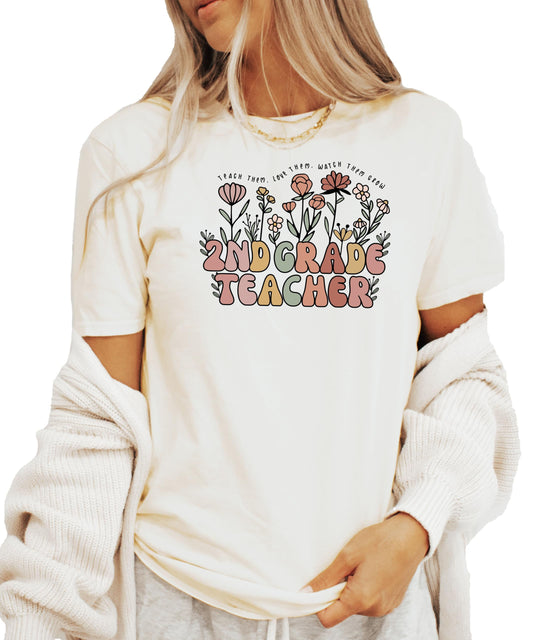 Front view of floral 2nd grade educator tee in peach with whimsical retro font design