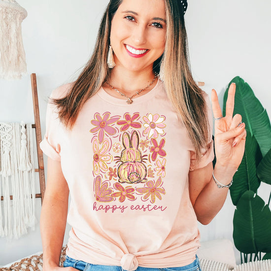 Flat lay of peach Happy Easter flower bunny shirt showing soft fabric and full graphic print — Olive Loves Apple
