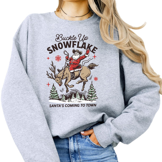 Model wearing gray Buckle Up Snowflake Santa's Coming to Town Christmas sweatshirt, casual holiday style