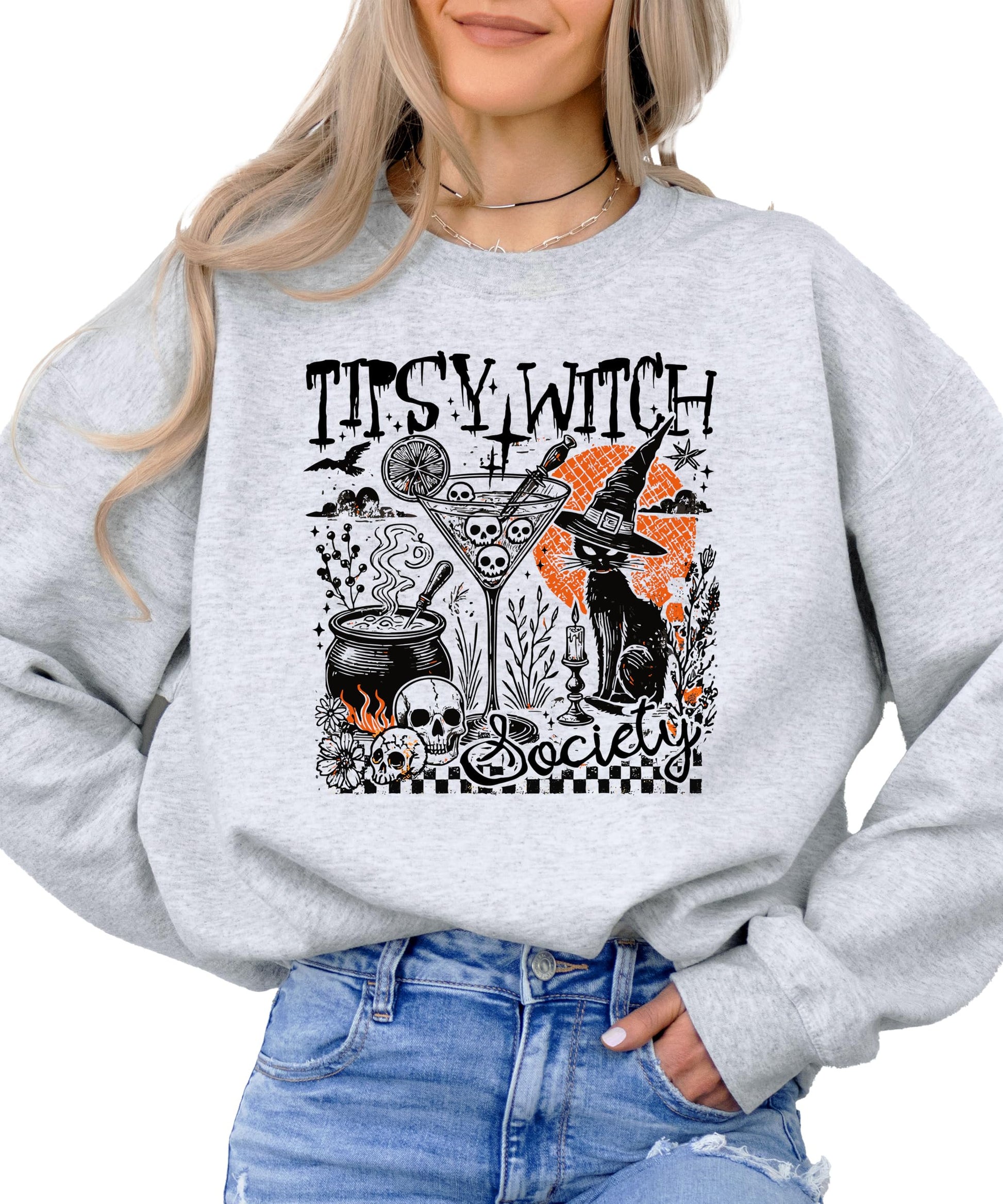 Close-up of Tipsy Witch Society graphic on black women's Halloween sweatshirt showing cauldron and cat details