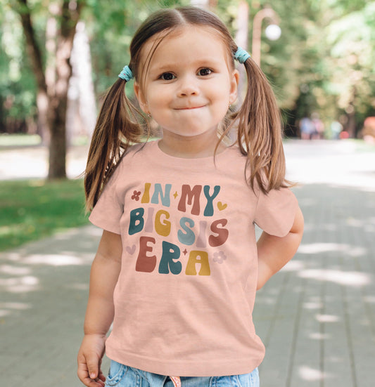 Flat lay of 'In My Big Sister Era' girls graphic shirt in natural color on light background