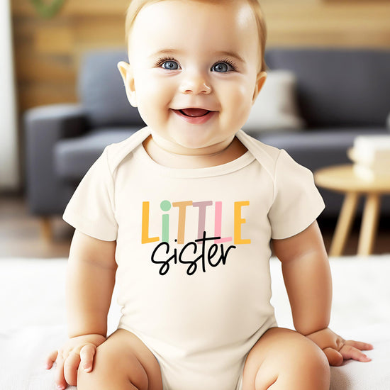 Little Sister baby one-piece bodysuit laid flat showing full design and natural colorway
