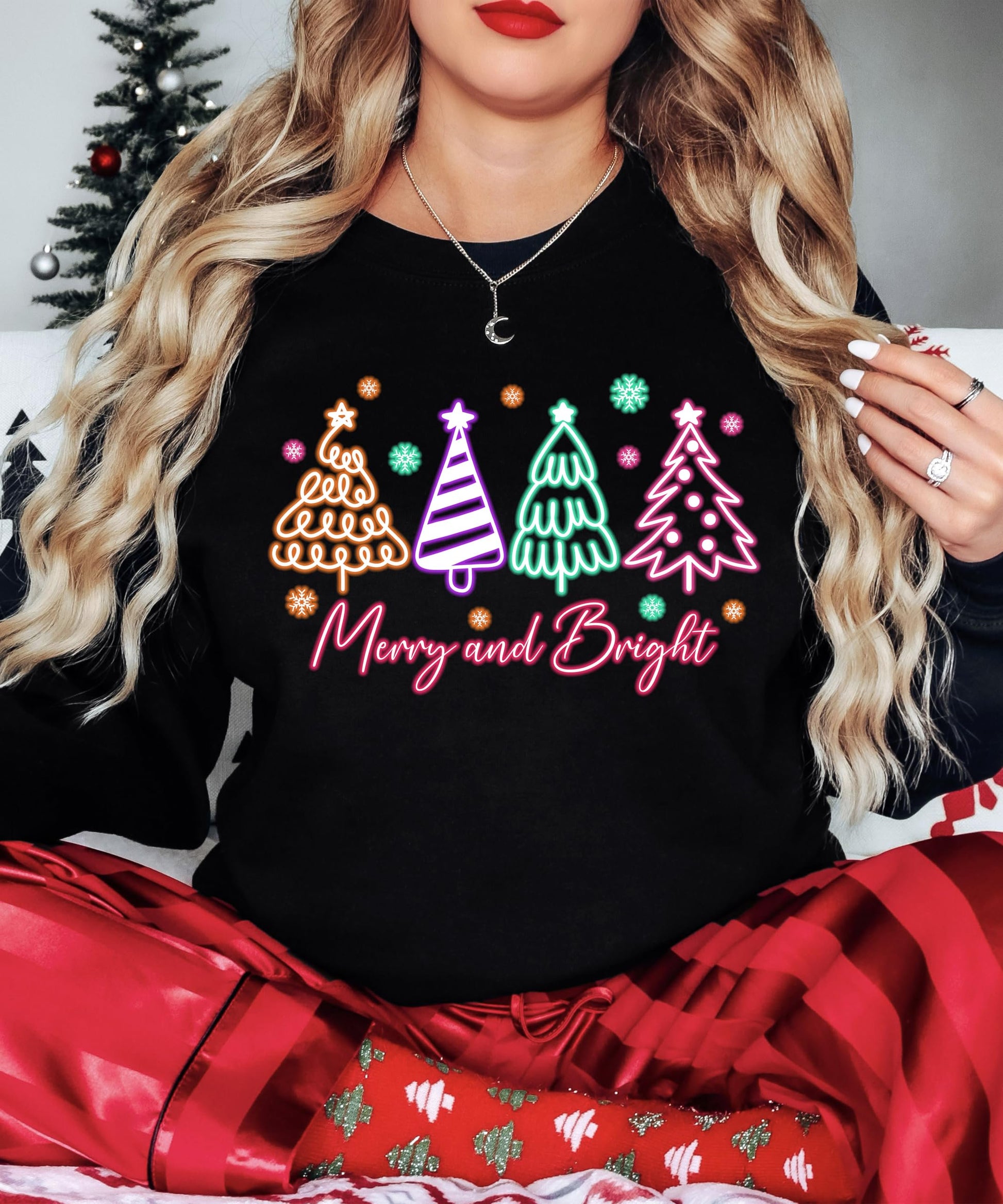 Close-up of neon Christmas tree graphic on black women's holiday sweatshirt by Olive Loves Apple