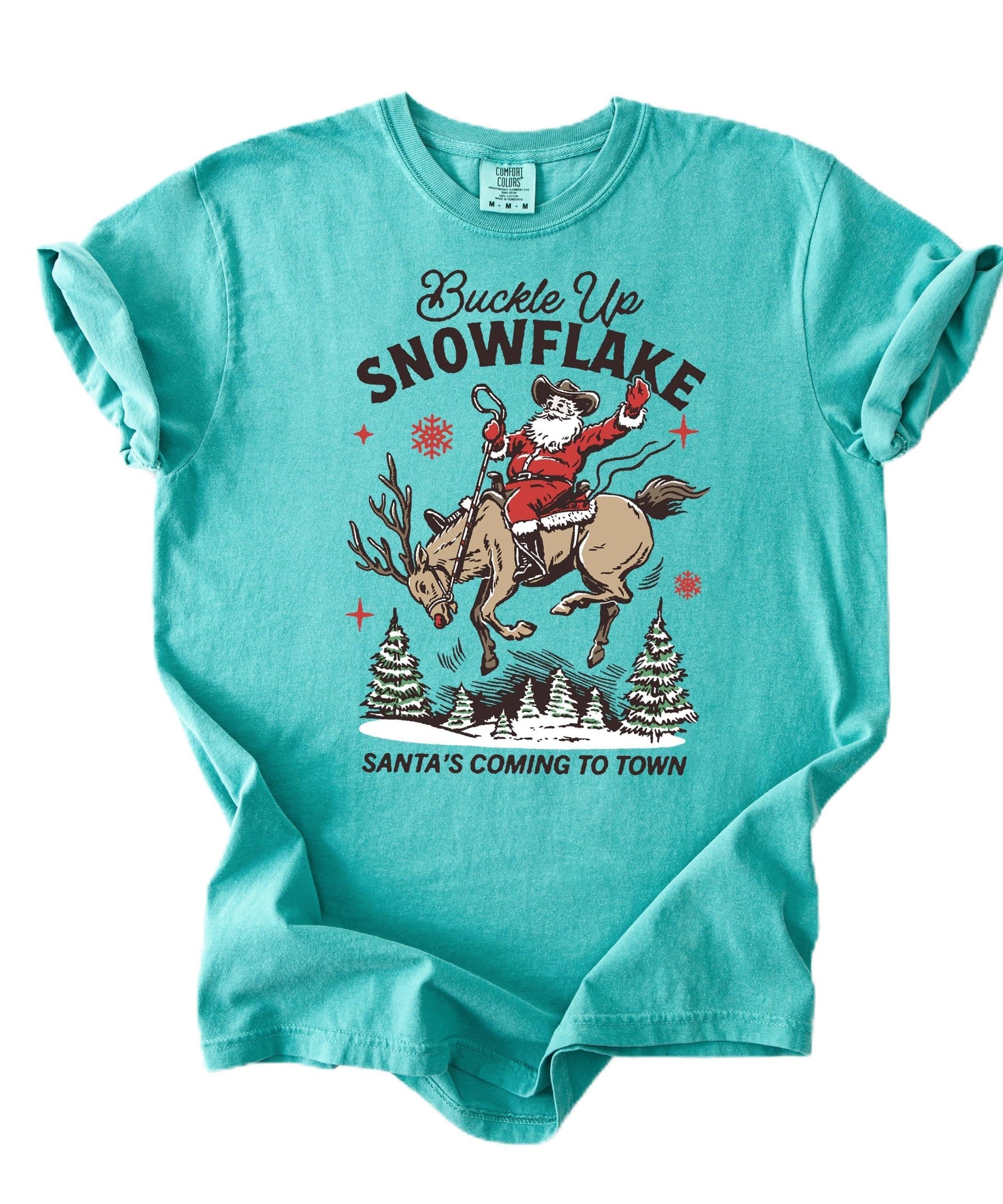 Ivory unisex western Christmas tee with cowboy Santa riding a reindeer snowflake design — front view