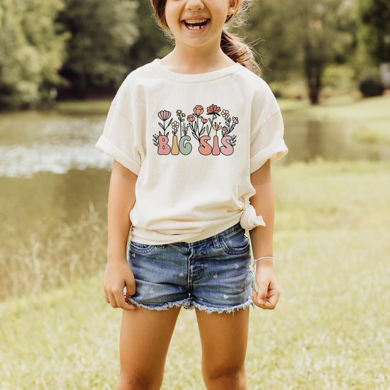 Detail shot of the big sis floral print on a natural cotton toddler shirt