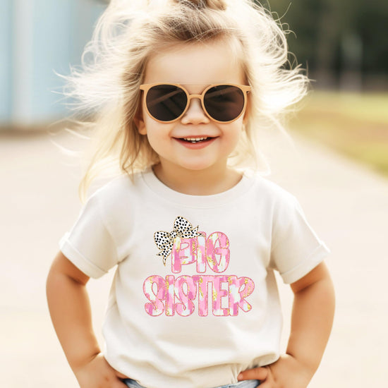 Flat lay of black Big Sister bow shirt for infant toddler and youth girls
